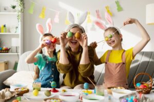 Happy grandmother and granddaughters playing with easter eggs