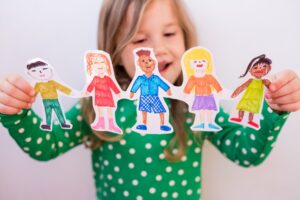 girl holding paper homemade garland of people of different races. Happy international children day