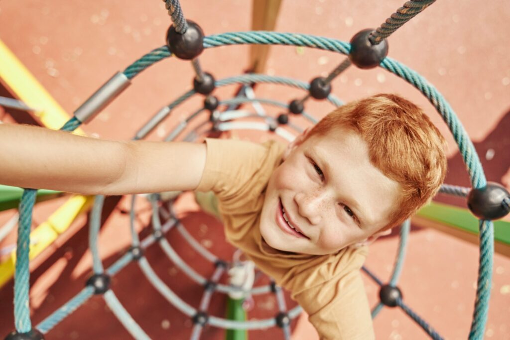 Ginger boy climbing at the playground
