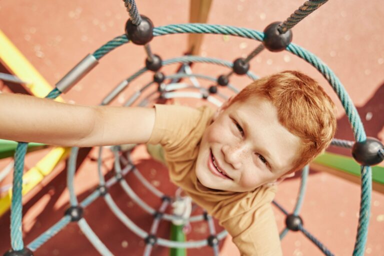 Ginger boy climbing at the playground